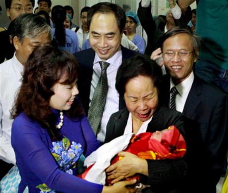 PCT nước Nguyễn Thị Doan Bộ trưởng Bộ Y tế Nguyễn Thị Kim Tiến vui mừng đón và bế công dân thứ 90 triệu của VN. Ảnh Dương Ngọc TTXVN